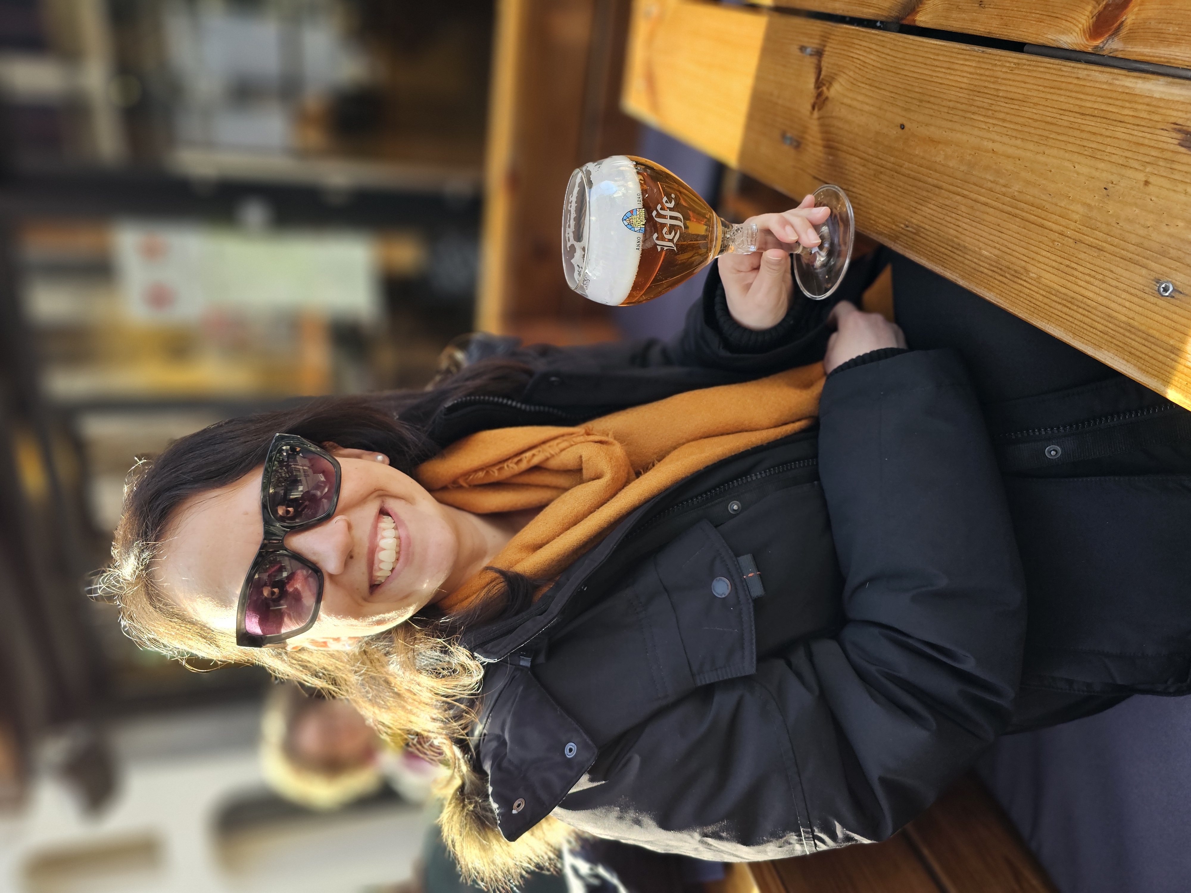 Amanda com uma cerveja em uma mesa ao ar livre, em Bruxelas